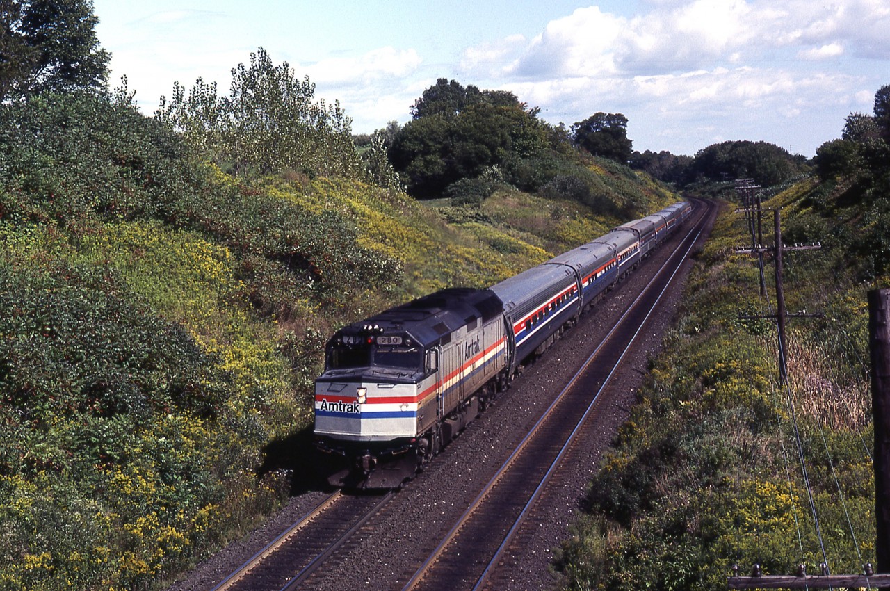 Through the late 1970s and into the 1980s/90s we lived in Chatham, and later Brights Grove. But we still had family, and friends, in the Burlington/Hamilton region. So if time warranted a pleasant day at trackside, I took full advantage of it. If memory serves, this was called the INTERNATIONAL, train 85 I believe.
A single F40PH has 9 cars in tow ( 8 Amfleets and a ?? Superliner) as he makes his way past the Inksetter Road iron bridge while headed for Chicago. A shame this train is no longer a through connection.