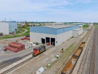 Seeing as the SW1200 rage is on, I thought I'd add another one of my 'now illegal' drone shots from last year. Unfortunately I've already uploaded most of my SW1200 shots, so this is about all I have left. On this day I was returning from a rather dull Bayview meet, and decided it was time to get a photo of 7304 at CN's Parkdale Yard. Here it sits, presumably shut down on this slow Saturday afternoon. This would be the last photo I would take not using a relatively high quality camera for the next two months, as my DSLR had disappeared the night before, and my drone would be out of service as well three days later due to a crash. Both my DSLR and drone are back today, though this photo definitely doesn't bring back the best of memories. It would be a long summer without any way to get decent photos.
<br><br>
In the right hand corner is the Niagara Escarpment, and Lake Ontario is also partially visible looking towards the transformer lines. The wye between the buildings stretches back behind them and skirts along the many steel industrial sectors that still somehow exist today. The track then merges back onto the Grimsby Sub at Stuart Street Yard. There was a time when manifests would actually work Parkdale Yard occasionally, though that changed and eventually the yard got its own dedicated switcher to switch around the Dofasco steel mill.
<br><br>
It's hard to believe it's been nearly three years since 7304 showed up here. It's been saved twice, in which it was rebuilt after a wreck with ONR 1517 in 1991, and then had its prime mover replaced a few years ago after the original one was damaged due to improper storage. It should be noted that although it is a rebuilt SW1200RM, the sides of the cab are painted red which is exclusive to 7304 among the rebuilt SW1200's. This occurred because of the wreck it had, and for some reason the cab sides were not repainted black. Though the red sides were standard among the unrebuilt SW1200RS units. None of those remain in service on CN so I guess 7304 can serve as a memory. It and 7311 are the only two SW1200 breed units in active service on CN today.