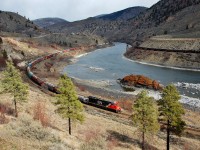 CN 3089 is approaching Spences Bridge at the head of a westbound mixed freight while a CP coal train is going east on the opposite bank.