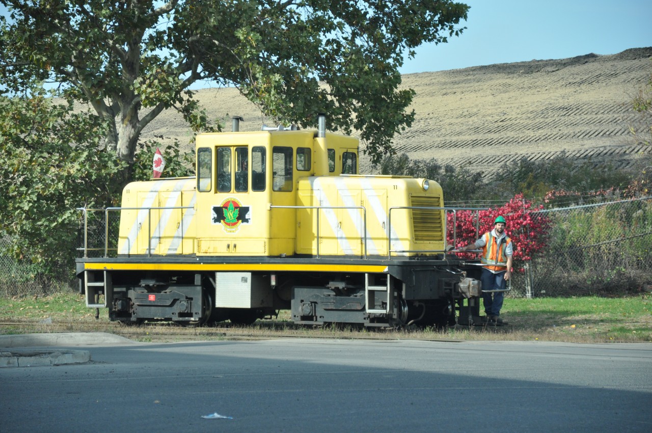 National Steel Car #11, in a new dress paint scheme, sits at Kenilworth, about to cross back into the plant. It hardly looks like the Industrial North End in this photo, thanks to the earth mound in behind. This unit, as with the other locomotive #12, has been at NSC since new in 1954.