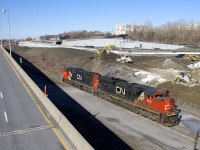 CN 372's power (CN 8011 & CN 5679) head east on track 29 (the only track left from what was Turcot Yard) to pick up CN 2921, which was the DPU on a grain train. At left are the eastbound lanes of highway 20 and in the distance is CN's brand new right of way, including a signal bridge. CN's main line is currently to the left of the highway here, but will be moving to the new right of way due to infrastructure changes in the area.