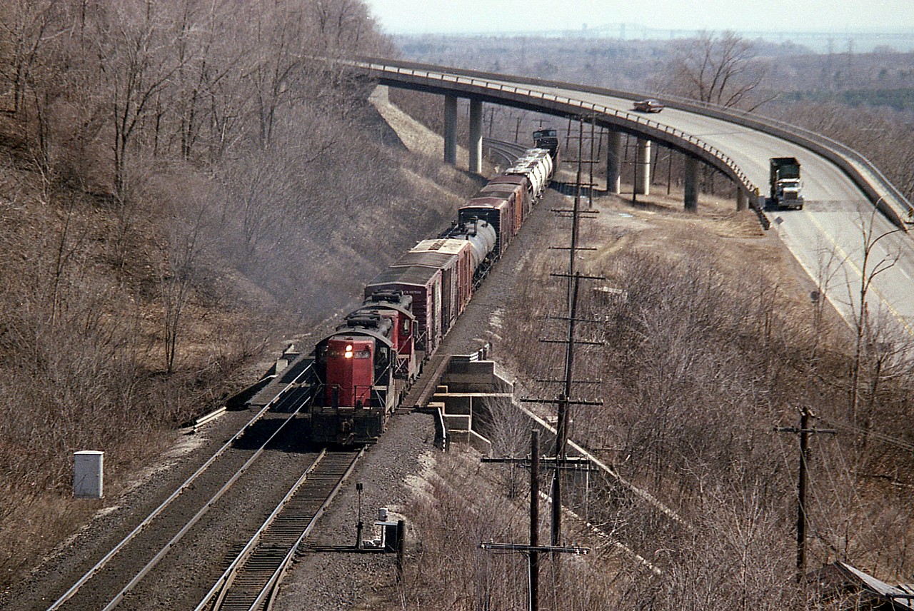 I'm assuming this is a Hamilton to Brantford local, even though it is powered by Geeps I used to see hanging out at Fort Erie. The 4560 and 4521 are seen westbound about mile 4, Dundas Sub. That is the Sydenham Rd bridge in the background. The image was captured from high above in that old Canada Crushed Stone structure that ferried crushed rock over the track to the stockpiles on the south side. Long gone.