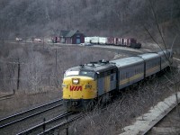 Mid-afternoon VIA #86 was cut from the schedule a long time back. No wonder. All the time I witnessed it, the train really didn't amount to much. In this view, the eastbound is rolling over the switch lead to the small "yard" behind the old Dundas station [fire: 1984] where often, as in this case, boarding cars and other misc equipment could be found. On the left is a stub; former lead to lower Canada Crushed Stone and related (Steetley) industries, and on the right is the track leading up to the loading area of the CCSL. The plant has been closed since @1973, and property abandoned at the time of this photo.