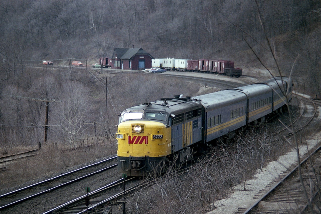 Mid-afternoon VIA #86 was cut from the schedule a long time back. No wonder. All the time I witnessed it, the train really didn't amount to much. In this view, the eastbound is rolling over the switch lead to the small "yard" behind the old Dundas station [fire: 1984] where often, as in this case, boarding cars and other misc equipment could be found. On the left is a stub; former lead to lower Canada Crushed Stone and related (Steetley) industries, and on the right is the track leading up to the loading area of the CCSL. The plant has been closed since @1973, and property abandoned at the time of this photo.