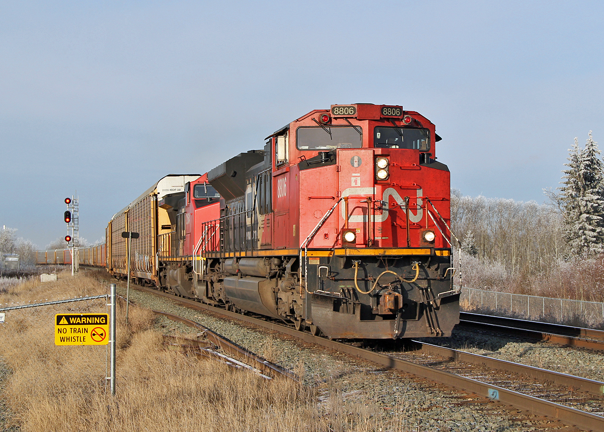 SD70M-2 CN 8806 and DASH 8-40CW 2164 (ex BNSF) head an eastbound train of auto racks onto the second main line at Ardrossan