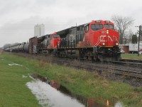 Not everyday is ideal for train watching but the grey wet day allows photographs to be taken from the other side of the tracks. Normally I would be looking into the sun! CN 3080 and CN3103 pass the newly formed pond heading west with a very mixed freight. The rain has been non-stop for days.