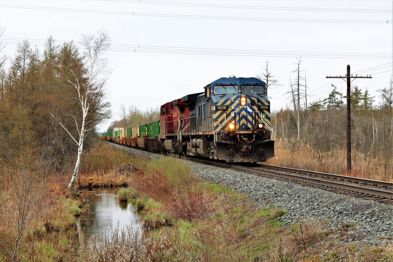 Container train, CP 142, led by CEFX 1028 and CP 9610 races over Concession 7 in Puslinch on a typical spring rainy morning. It sure is nice to see the spring colors returning and help us get rid of the winter browns.