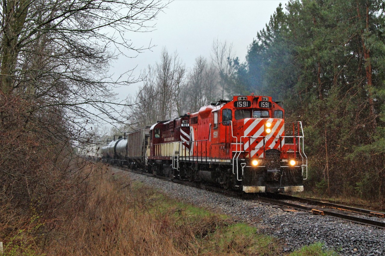 Its just pouring rain as GJR 1591 (GMD GP9u) with GJR 181 (MLW RS18u), accelerate from Guelph Junction across Side Road 10 on their way to work in Guelph. The rain sure does bring out the colours.