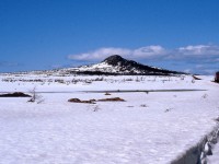 GAFF TOPSAIL - Terra Transport Mixed Extra 945 West approaches the hill known as 'Gaff Topsail' on April 20, 1987 while en route to the Flag Stop of the same name. Synonymous with Newfoundland Railway lore, the Gaff Topsail was one of four hills rising up from the plateau being named after the sails on a ship, the others being Main, Mizzen and Fore. Now just west of Summit, the train had already begun her 70 mile descent to near sea level at Corner Brook and the photographer and his girlfriend would continue to see wonderful vista such as this on their first Newfoundland train ride, making memories to last forever.   