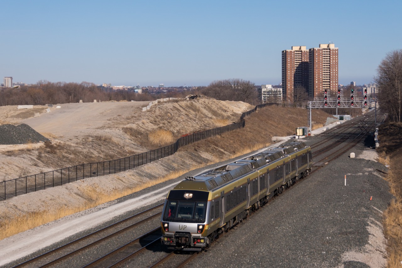In the middle of a 25 minute, 15 mile trip to Toronto Pearson International Airport, Nippon-Sharyo DMU-A 1009 leads train 4087 through the plant at Humberview on number 3 track. This view will change in the coming years as work to build the fourth track on the Weston Sub occurs in addition to tunnel work to allow the extra track under Highway 401. Finally, under the giant mound of fill is the future site of the maintenance and storage facility at Resources Road for the electrified UP Express.