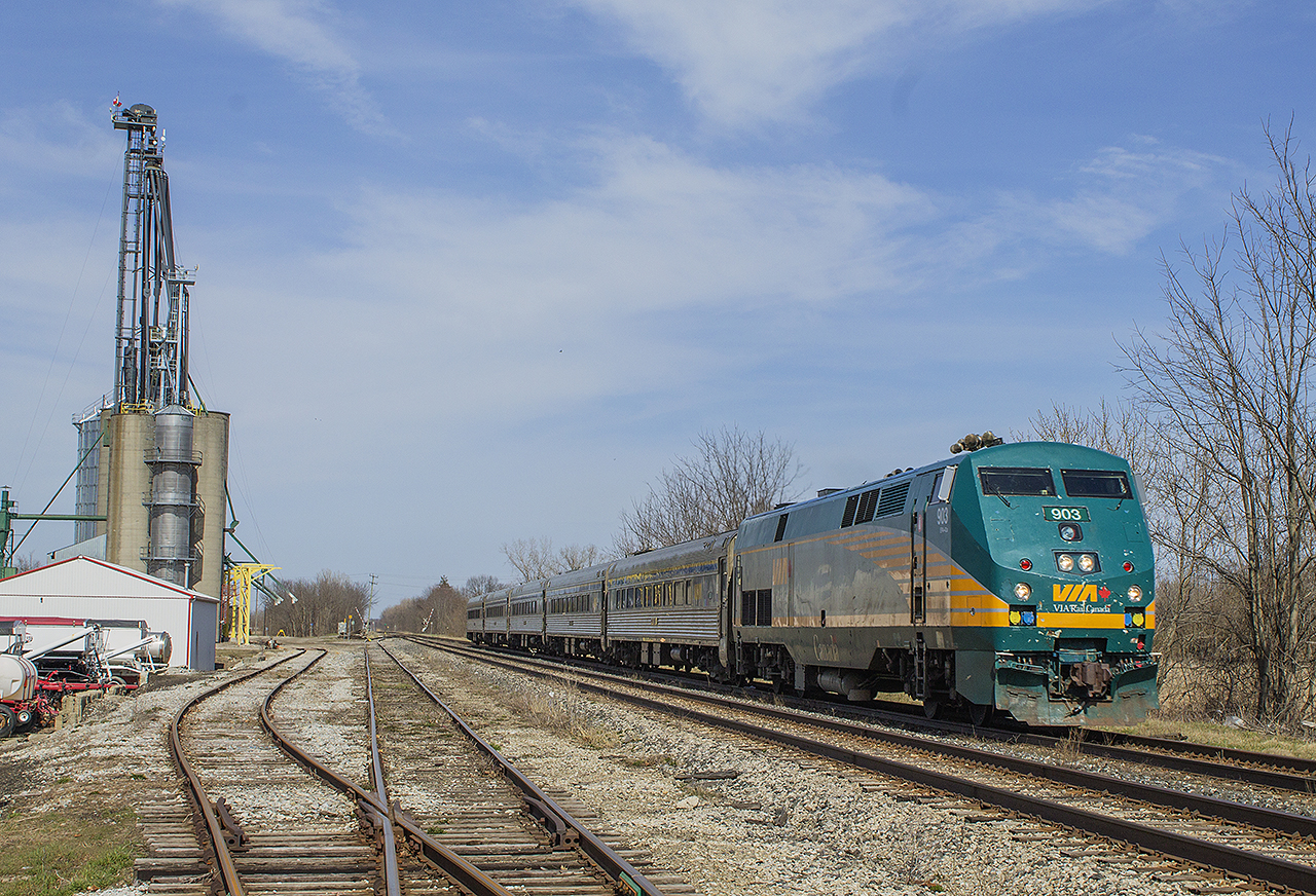 Train 73 passes the quiet sidings at Thamesville on a very sunny, yet quite warm Sunday afternoon. It is approaching the Victoria Road (Hwy 21) crossing with it's horn blaring. In the distance, you can see the gates coming up to allow traffic through once again at the Longwood Road (Hwy 2) crossing.