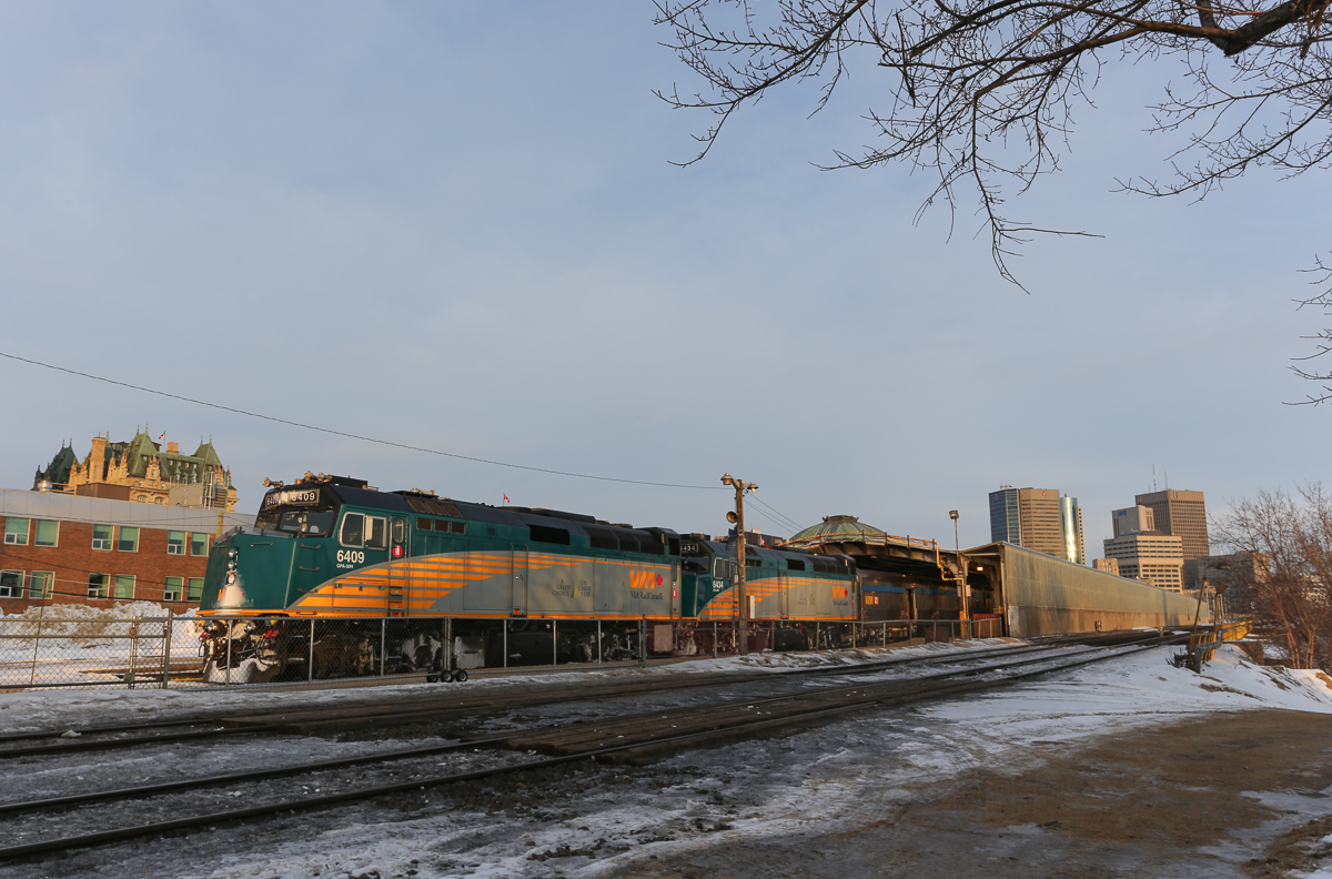 The westbound Canadian just arrived at Winnipeg in the early morning.  At left, gothic roof of the Fort Garry Hotel can be seen.