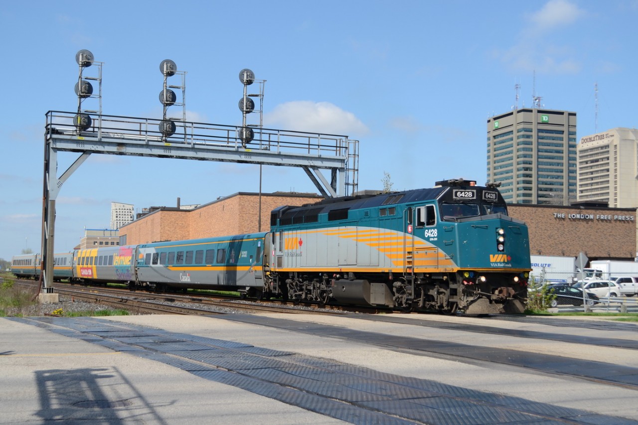 VIA train #72 pulls out of the VIA Rail London train station, and under the first Signals for the CN Dundas Sub, with London Free Press building in the background and other downtown London Buildings.