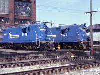  Conrail Canada Division GP-7's 5822 and 5824 catch some rays behind the St Thomas diesel shop on April 24th 1982. 5822 appears to be stored/out of service as the stacks are bagged.