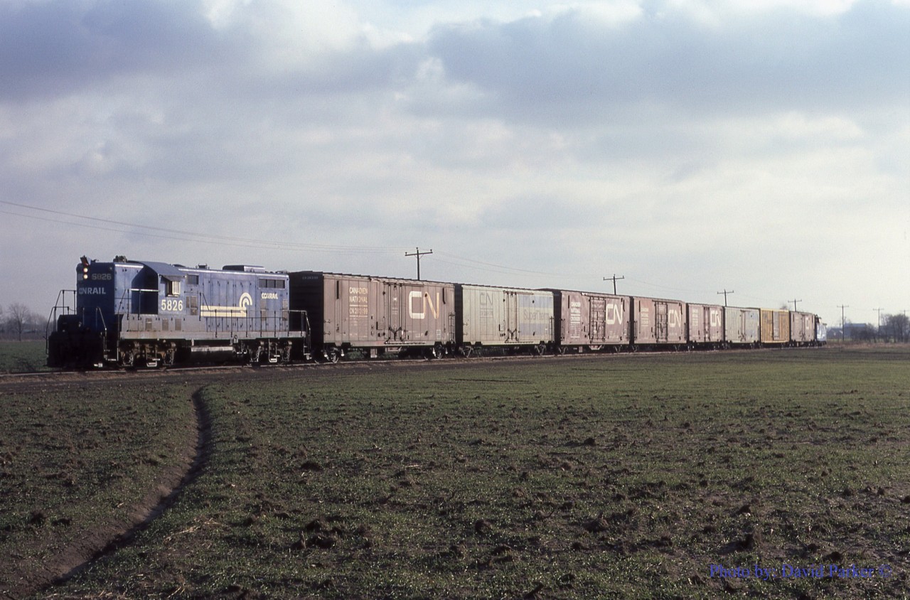 Conrail GP-7 5826 ambles Northbound with the "Leamington Local" train WQST-1 on a chilly December 20th 1984 across the flat farmland of Essex County North of Leamington, Ontario.  Upon arrival at Comber, the cars will be set off for "The Plug" WQWI to lift to St Thomas. WQLE will pick up empties for Heinz and return to the Southernmost rails in Canada.