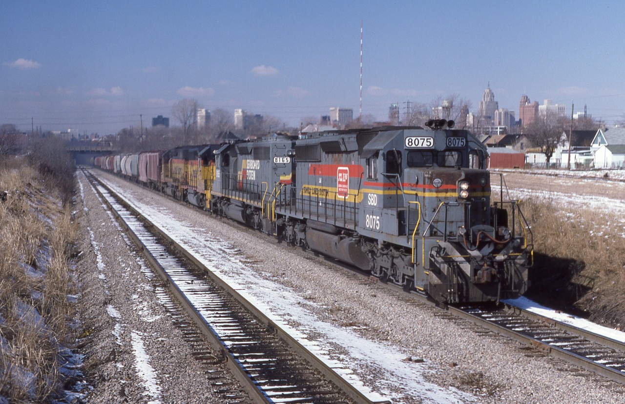 A mixed quartet of CSX power (8075-8165-4166-7516) brings the Rock Train up and out of the Detroit River Tunnel into Windsor, Ontario on March 15th 1983.  The Phospahte rock, originating in Florida will be interchanged to CP Rail for furtherance to Port Maitland.