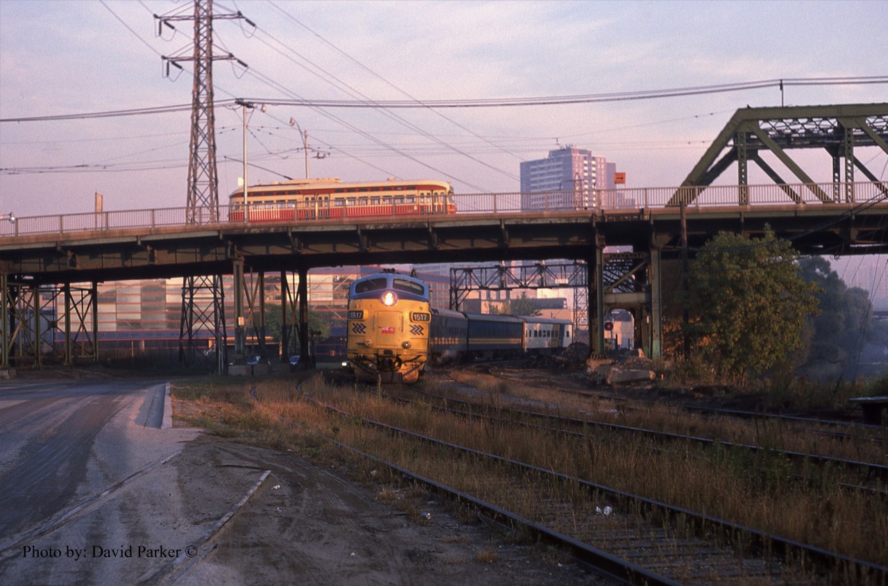 On its last Mile and a half into Toronto Union Station, Ontario Northland overnight sleeper from North Bay lead by FP7A 1617 ducks under Queen St as a TTC "PCC" streetcar passes overhead in the early morning of Oct 16th 1987.