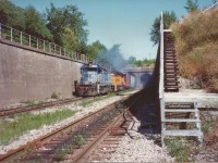 CSX train emerges from the Windsor Detroit Railway tunnel up grade to Windsor South. This train would go on through Essex county delivering shipments along the way eventually ending up in St Thomas. As a CN employee this vantage point was accessible at the time from the stairs to the right. These were all blocked off and fenced in in early 90's when the right tunnel was enlarged to accommodate auto rack rail cars. Also people were trying to enter the US through these tunnels.