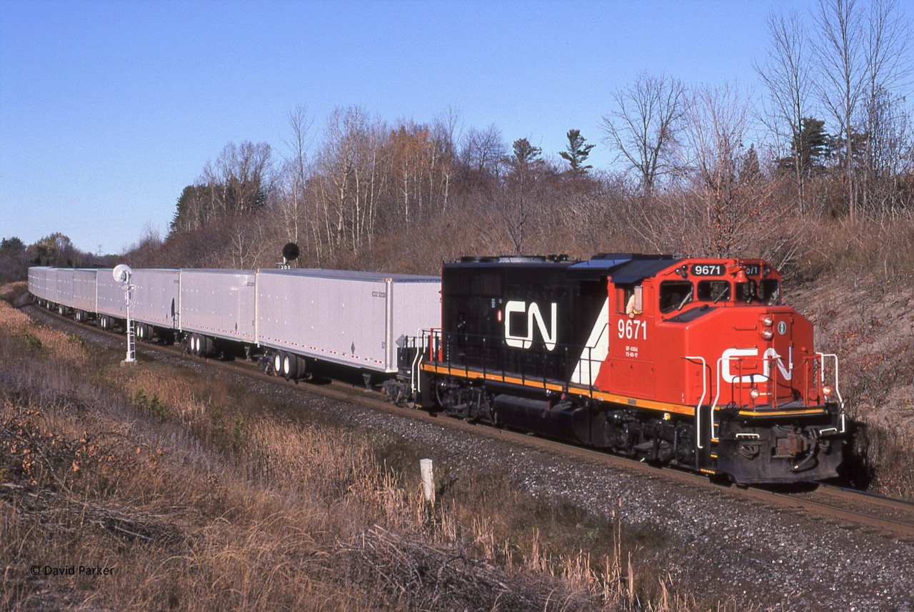 A nice clean CN 9671 leads train 145 as it splits the signals at Mile 30 (Scotch Block) Halton Sub, North of Milton Ontario on Oct 29th 2000 with ECOZ trailers.