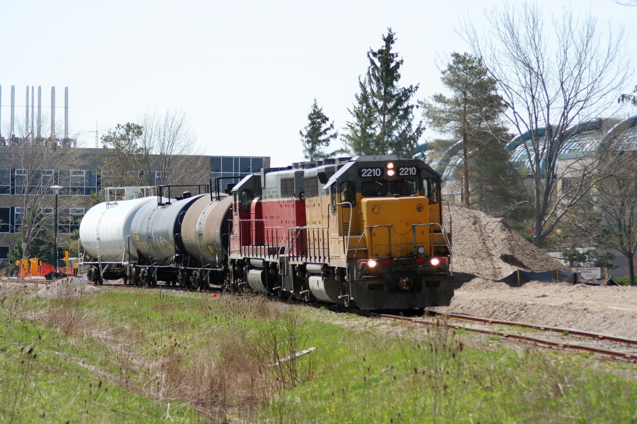 During a spring morning, Goderich-Exeter Railway train X580 is seen rolling through the University of Waterloo campus as it approaches Columbia Street in Waterloo. Units LLPX GP38AC 2210 and GEXR GP38AC 3835 are hauling three tankers to Elmira on the Waterloo Spur.