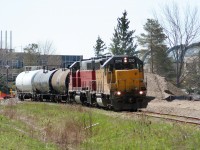 During a spring morning, Goderich-Exeter Railway train X580 is seen rolling through the University of Waterloo campus as it approaches Columbia Street in Waterloo. Units LLPX GP38AC 2210 and GEXR GP38AC 3835 are hauling three tankers to Elmira on the Waterloo Spur. 