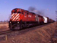 A westbound at Dillon Road with 4733 and an SD40-2 show the straight, flat terrain that exists on the Windsor Sub west of the Chatham diamond with CN. (the eastward Absolute signals can be seen in the distance). Much of the pole line is still in place, and an early spring comes to the 'Great Southwest'.