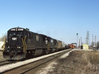 Westbound NS train 27, St. Thomas to Windsor, passes by the newly constructed CN Chatham East office and is about to cross the CSX diamond. A piece of track machinery is taking care of the eastbound roadbed, while covered hoppers fill the CN/CSX interchange. Train 27 has obviously stopped at one of the on-line elevators, as evidenced by the two hoppers behind the power. Barring further delay or work to be performed at the small CN yard, the train will be yarded at the water's edge in Windsor in about 90 minutes. 