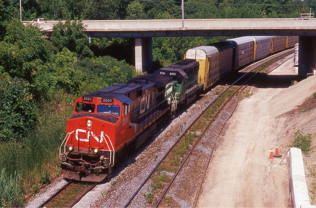 Something's missing... I haven't had the chance to go out recently and my dad's been scanning some of my old slides for me so I thought this would be a good opportunity to do a "memories Monday" (somehow I doubt that'll catch on). Not a lot of info I have on this shot. Westbound autorack train with CN 2551 and BNSF 6791 in control. The noteworthy aspect is the building of the third main as part of GO's expansion into Hamilton. It amazes me that this was 11 years ago when I was at the young and unknowing age of 9 years old. A lot's sure changed since then with GO's further expansion into Hamilton via Harbour West. Will be a nice addition once they finish the station next century.