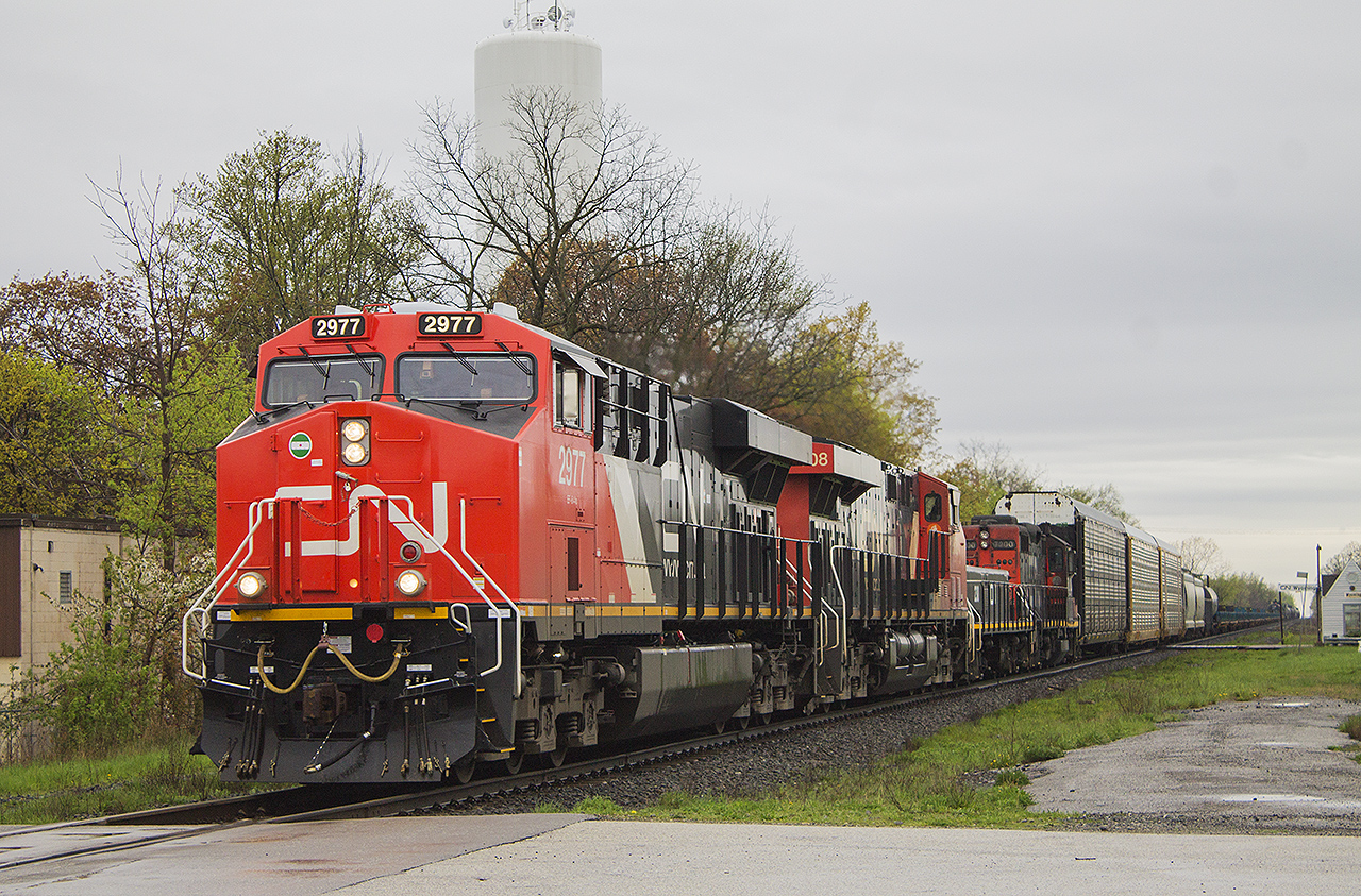 Marcus W Stevens stated that "when it rains it pours - if the weather is bad then all the interesting power will show up". On a recent and depressing trip last week to Sarnia, I ended up detouring to Wyoming. Of course, Mother Nature decided against my wishes for my time spent in that area for a nice sunny day. But note what follows lead engine 2977 across Broadway Street - 3 other units including slug #203 and an old friend in 7200. These units are usually seen shunting around the yards at Sarnia. And yes just off in the distance is VIA's little bus shelter they call a station, replacing a much larger building that once stood in the foreground.