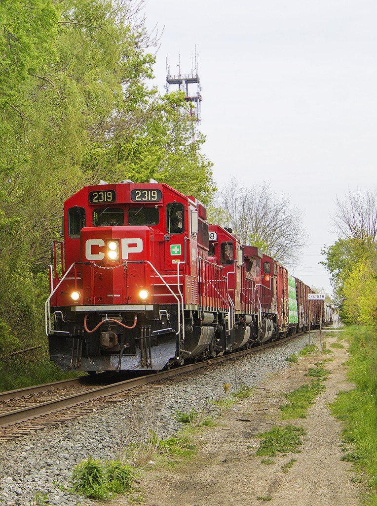 The benefits of having the Windsor Subdivision right behind the place you work at can be quite challenging at times. Especially while having to work, hearing trains rolling on by as many as 6-7 in an 8 hour shift! However, every once in awhile, patience pays off and luck is on your side when you are on an afternoon break. With only 15 minutes to spare, I quickly walked over to the West Street crossing, and sure enough, just after 5 minutes of watching, this freight rolled on through. CP 2319 leads the charge, with a second similar unit behind it, and a larger unit trailing as the third engine. Normally it would be reversed with a large unit leading the charge, but not today. I like the smaller units as that CP red shows off better against the 'spring green' budding in the trees.