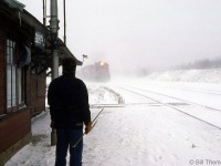 The operator at CP's Guelph Junction station stands at the ready, train order hoop in hand, to hoop up on orders to westbound CP #501 as it approaches the station during a snowstorm. This exemplifies the challenges operators had to deal with sometimes, passing on train orders in all types of weather in all seasons.
<br><br>
Hooping up orders at Guelph Jct to the westbound Pick Up: <a href=http://www.railpictures.ca/?attachment_id=16593><b>http://www.railpictures.ca/?attachment_id=16593</b></a>