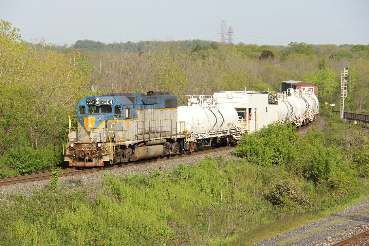 I know there has been a multitude of shots of the Weed Spraying Train but being the foamer that I am, I was itching to share another action shot, this time on the Hamilton Sub. First of all, thanks to Eric Portelli for the timely FPON post that this train was going to be tied down at Guelph Jct. overnight May 22 into the 23rd. Thinking it would be a long shot, I went to Guelph Jct. to check for it Tues. May 23 morning (a little diversion from my usual path to work). It wasn't there; I was too late. At this point, I still had no scanner on and no solid information that it was going to run south on the Hamilton Sub (but I had a feeling it would). So, because I work in Hamilton, I followed the line south. At one crossing, I saw what appeared to be the tail end of a train. Then I took a road semi-parallel to the line, and I got it!
Not taking any chances, I hustled to Hamilton West, and here it is, trundling southbound towards the Hammer at about 08:20. This is definitely one of those 'rare' train locomotives so I'm happy I got the chance to shoot it. Despite the long commute from K-W, there are benefits to working out of town :) (and lots of tunes during the commute!!!)
