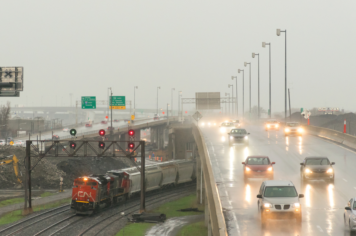 CN 310 ducks under highway 20 a few minutes after the sky opened up and a torrential downpour began (with me on a busy overpass!). Needless to say I did get soaked, even if I was shooting while holding an umbrella.... Power is CN 8011 and CN 2547, with CN 2245 mid-train. The south track is lined for VIA 63.