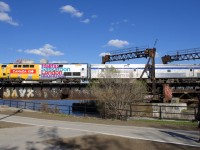 VIA 64 is nearly into Montreal's Central Station as it crosses the Lachine Canal at CN Wellington with VIA 906 leading. VIA 906 is wrapped for Canada's 150th anniversary and 4 cities served by VIA Rail are listed on each side.