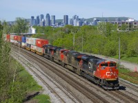 CN 120 with clean CN 8900 leading CN 2275, CN 8807 & CN 2233 has 636 axles as it heads east on the St-Hyacinthe Sub, with the skyline of downtown Montreal in the background.