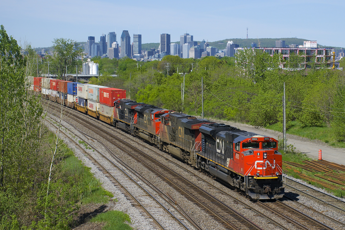 CN 120 with clean CN 8900 leading CN 2275, CN 8807 & CN 2233 has 636 axles as it heads east on the St-Hyacinthe Sub, with the skyline of downtown Montreal in the background.