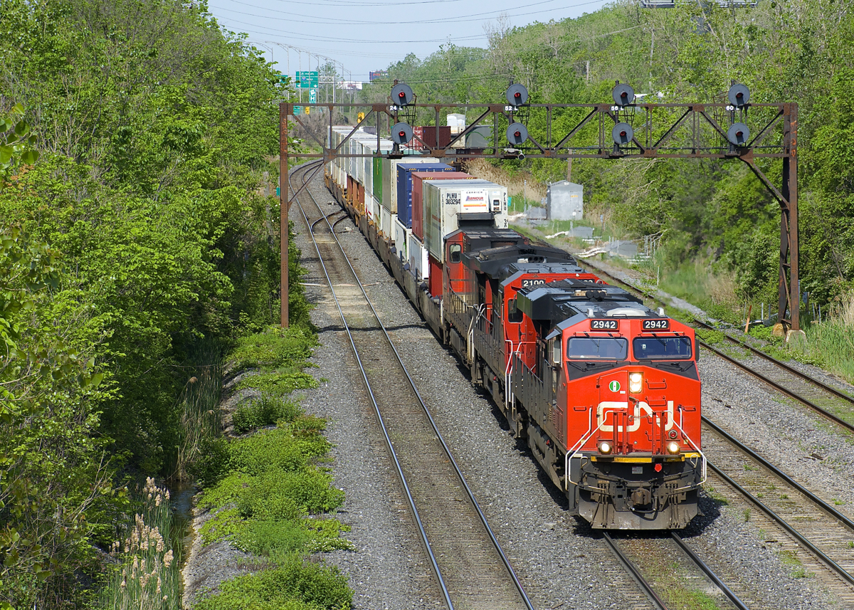 CN 120 has CN 2942, CN 2100 & CN 2648 up front and CN 8853 as mid-train DPU as it leaves Taschereau Yard. This 640-axle long intermodal train originated in Toronto and will terminate in Halifax.