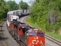 CN 120 has CN 2942, CN 2100 & CN 2648 up front and CN 8853 as mid-train DPU as it rounds a curve on CN's Montreal Sub. This 640-axle long intermodal train originated in Toronto and will terminate in Halifax.