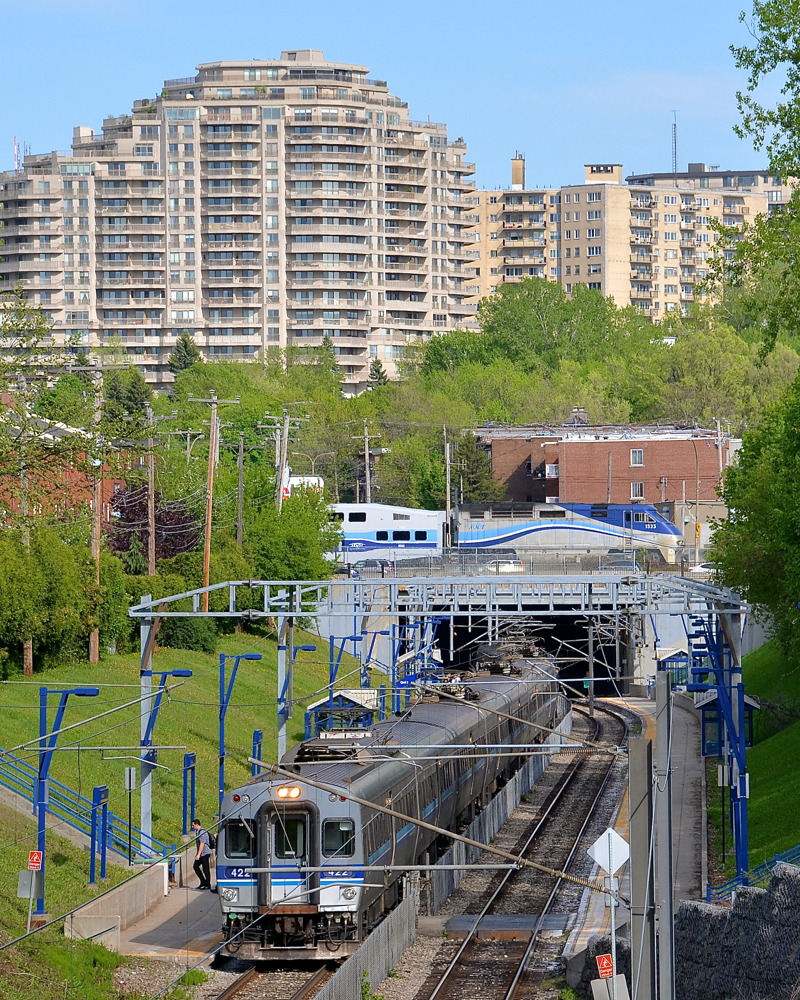 In this shot we see AMT 945, an electric train for Deux-Montagnes stopped at Canora Station at the north end of the Mount Royal tunnel below. Above is CP's Adirondack sub, where AMT 187 for Saint-Jérôme is passing at the same time with AMT 1323 pushing.