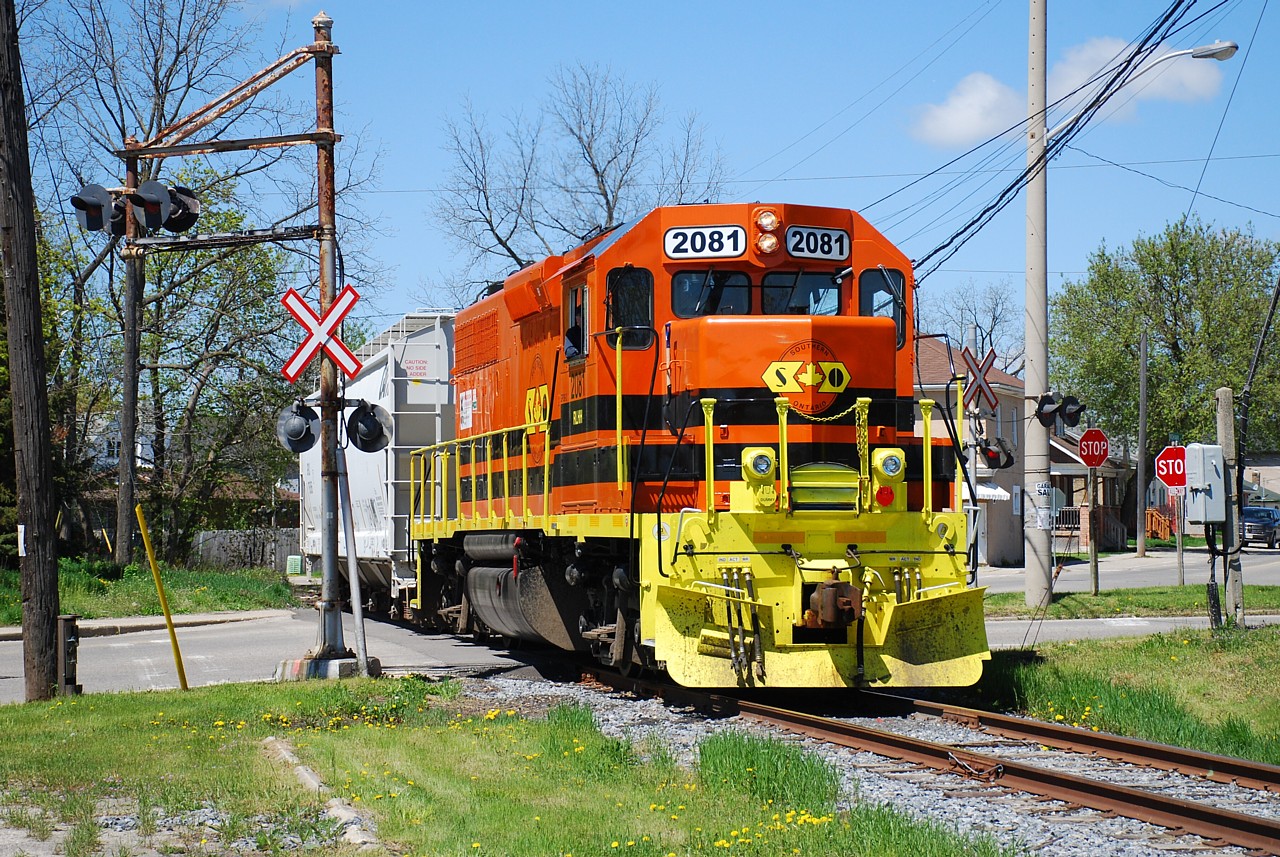 RLHH 2081 and one hopper is shown crossing Mohawk Street, making a second trip to Ingenia after failing to rerail a derailed hopper using old-fashioned rerailers.    A heavy-duty crane was later summoned to lift the car back on the rails near the former site of TH&B's Newport Yard.