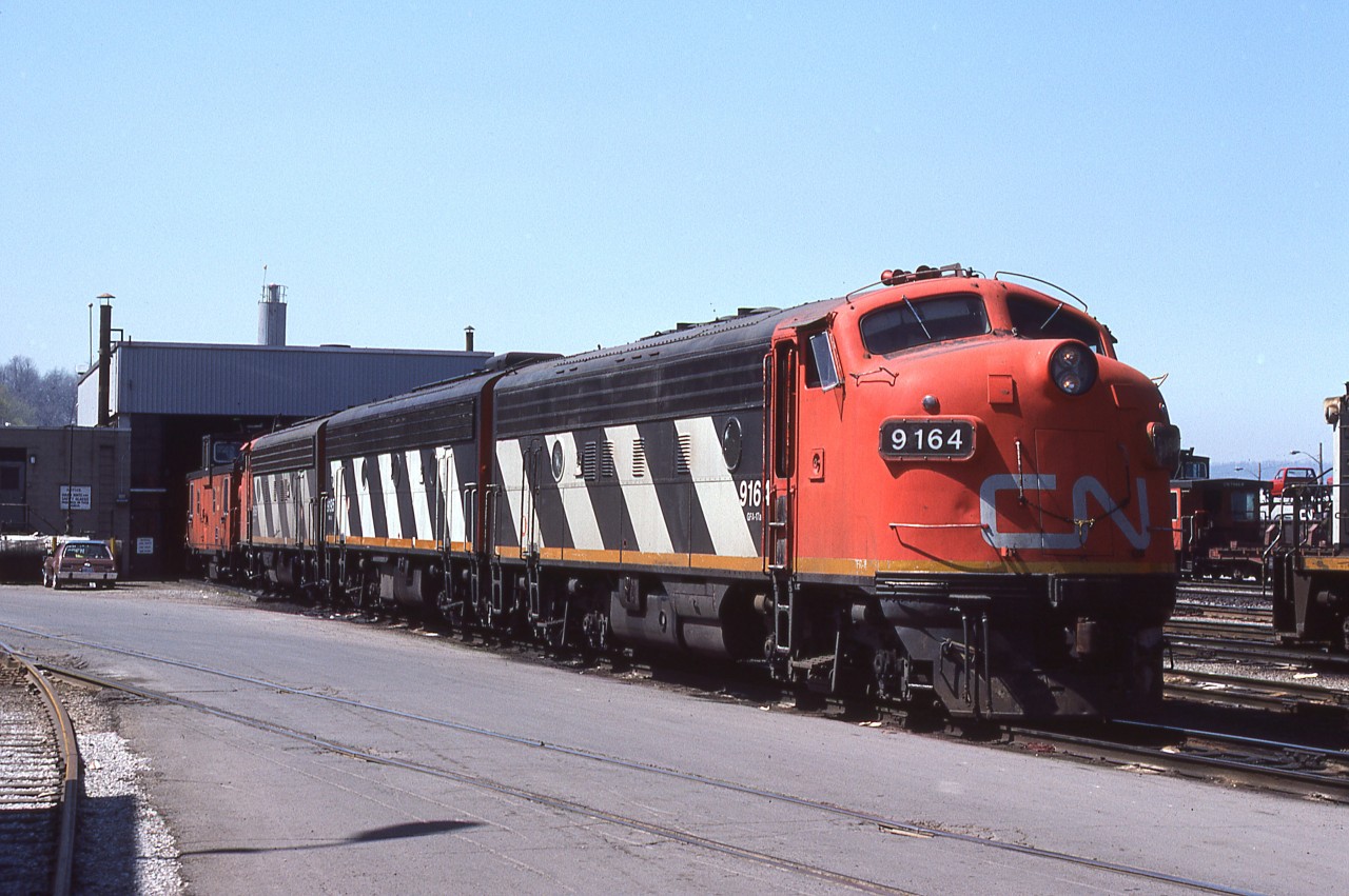 A Mike McIlwaine photo.
A matching ABA set of F7's idles at CN Stuart Street engine facility, awaiting their departure on 'The Nanticoke Steel' run. Soon they'll be gingerly tip toeing on the Ferguson Avenue street running as they make their way through the south end of the city, and climb the escarpment towards Rymal, Caledonia and beyond. A lot of things in this photo are gone. But thanks to Mike, and others, we can see what used to be. How these units came to Hamilton is an interesting story ( for non-employees ) - they were no longer required at places like Prince Rupert and Edmonton, so the Assistant Manager of Motive Power asked the Hamilton shop foreman if he would be interested in having 2 ABA sets based here. To his surprise the Foreman said 'Yes' and the rest was railfan heaven !