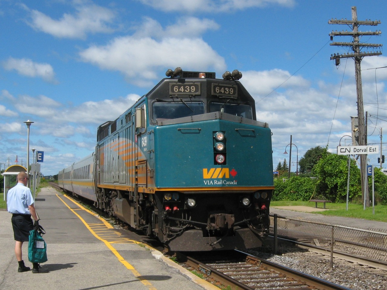 DORVAL DELIVERY. The VIA Station Attendant at Dorval waits for 6439 with the #60 from Toronto to stop so that he can deliver the documents in the bag on the beautiful late morning of August 10, 2013. While travelling from St. John's to Sherbrooke for the 2013 Canada Games to watch their son play for the Rock, it gave this Newfoundland Railfan and his wife yet another opportunity to ride the VIA Air-Connect from Trudeau Airport to downtown Montreal, and capture some train action in the process.