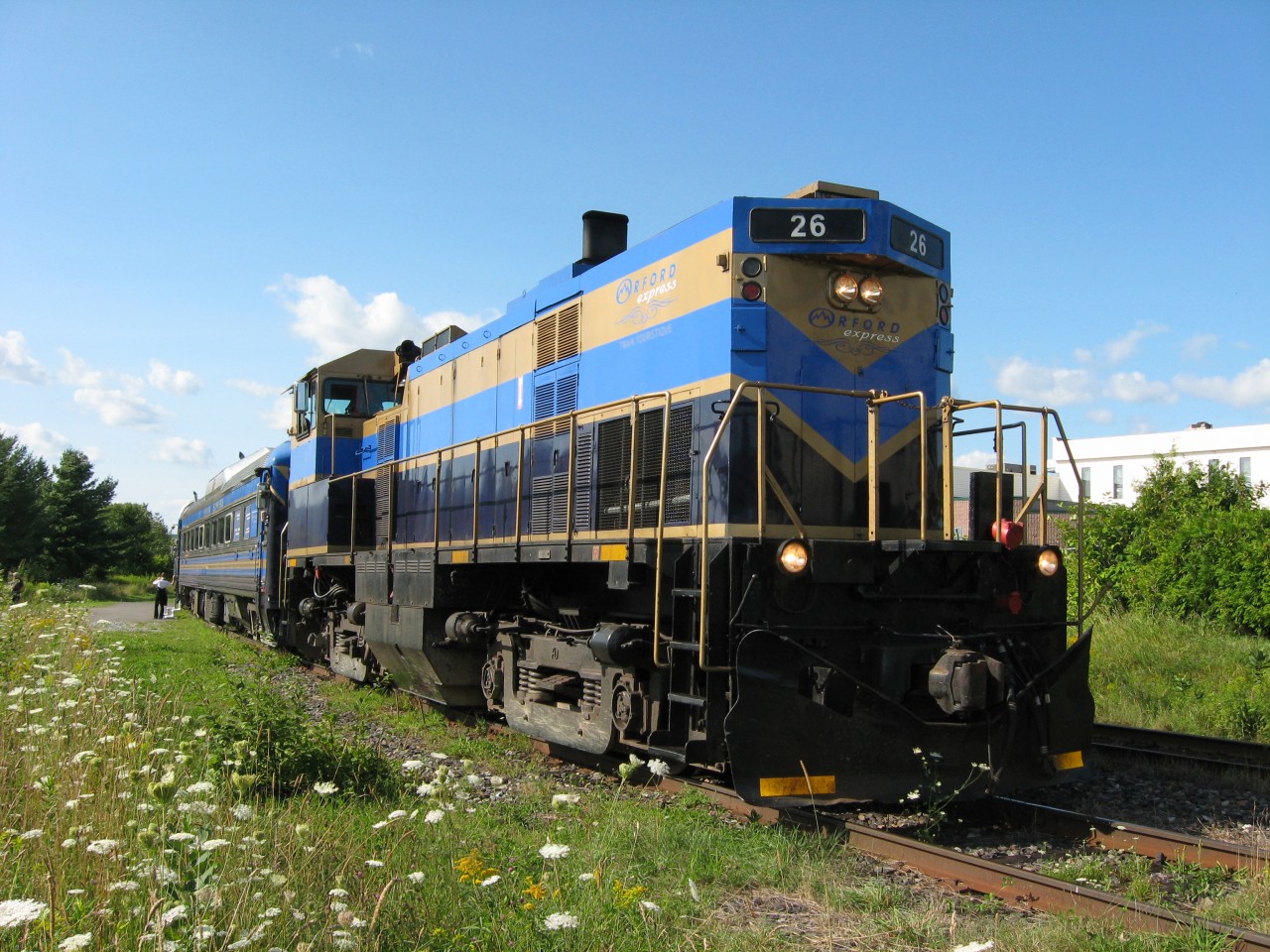 The pristine MLW M420TR # 26 of the Orford Express prepares to depart Magog for Sherbrooke on the beautiful afternoon of August 11, 2013. Travelling to Sherbrooke to watch their youngest son Thomas represent Newfoundland and Labrador in the sport of soccer during the 2013 Canada Games, it allowed this railfan and his wife Michelle to experience not only one of North America's most beautiful tourist trains but also one of their most memorable dining experiences anywhere.