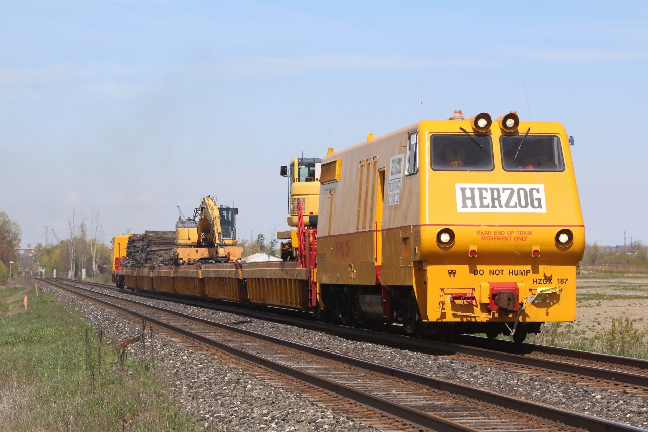 Canadian Pacific has begun spring cleaning along the Galt subdivision. here we see the Herzog train heading west out of the dip in Hornby after crossing over from the north track to the south. Lead unit #187 is a custom built unit that appears to be built on a GP9 frame (I would love to know the history), the rest of the train is converted container flats upgraded to allow front end loaders to travel the length of the train. The train has been busy collecting old ties that have been discarded along the roadbed for a number of years.