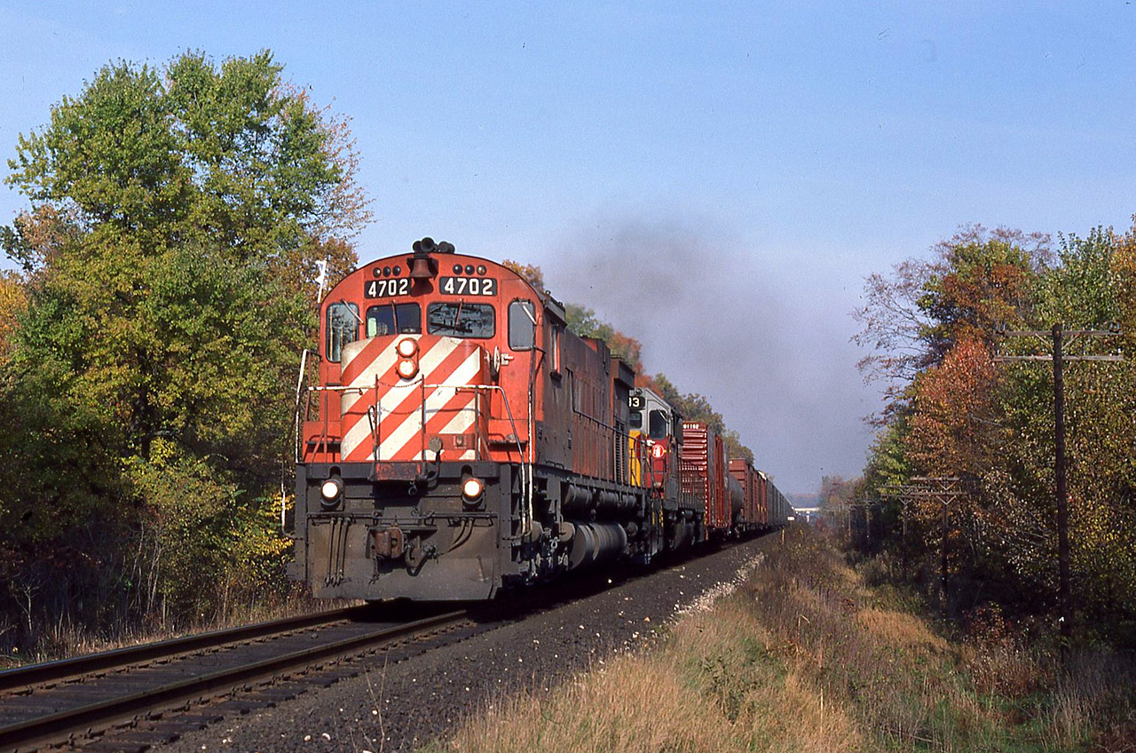 Once again we find CPR leasing power. Among other things, they borrowed ACR units 180, 182, 183 and 185 that year. A westbound shot at Springwell Road ( 1 mile west of the 402 overpass) with 4702 and leased Algoma Central SD40-2 183. It’s upgrade through here and the leaves on the rail were giving this guy a little trouble.