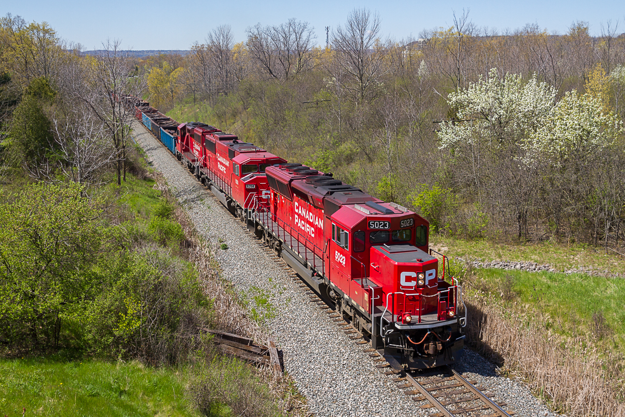 CP 5023 charges up the grade out of Hamilton with a trio of EMDs for power and a 24-car management train.