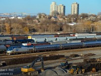 And a shot that you could only do (recently - anyone have a photo for Time Machine?) for about a year or two - during construction of the new Cargo Flo yard (and future CN Dundurn plant) the foreground was cleared of poles and trees - and the 1964 built CN Diesel Shop -  and in the spring you can shoot Amtrak from the south side as they pass Hamilton Yard. The Burlington Skyway is in the background, as is the lift bridge (which once had rail - as seen in this <a href=http://www.railpictures.ca/?attachment_id=29369 target=_blank>Paul Sherlock photo</a>) and of course, the pretty part of North Hamilton increasingly gentrifying with Toronto Yuppies, Millenials, and Hipsters looking for a 'cool place to live' near the new GO station. Property values are also going up. The vantage point is called "Crooks St" and you can still watch the action, sorta, except CN's Cargo Flo yard (plastic pellets cars) block all visibility to the mainline. A nice place to watch the water and the rail yard when you have some downtime.