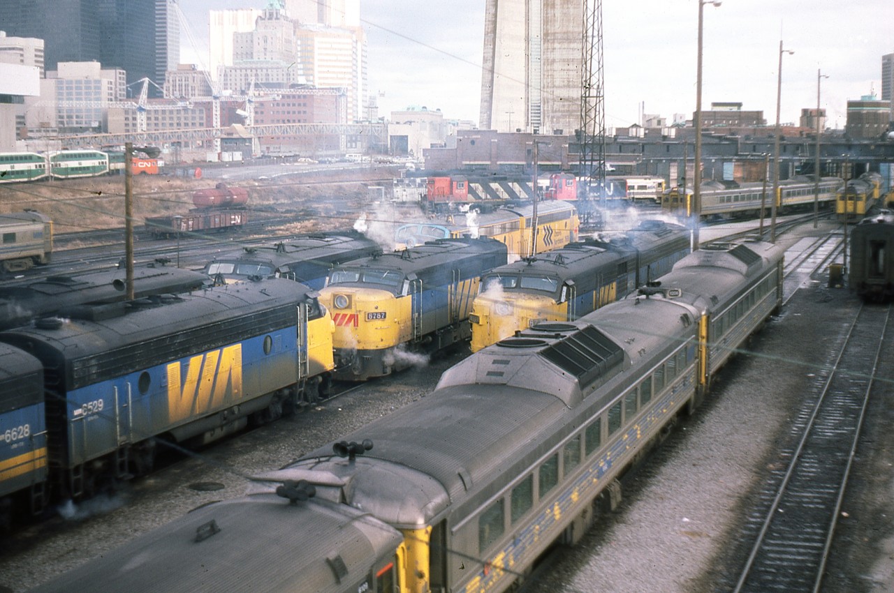 A Doug Lawson photo.
A candidate for the Time Machine.
Del Rosamond's 1961 photo - http://www.railpictures.ca/?attachment_id=17034
In May 1961, Del Rosamond stood on the Spadina Ave bridge and captured a bevy of GMD1's, sprinkled with cab units, switchers and geeps. Very few were carrying the new paint scheme introduced in 1960.
In December 1982, Doug Lawson stood in nearly the same position and captured a different look, although the end goal is the same - passenger service. Here we can see a matched pair of Ontario Northland FP7's, along with VIA F9's and FPA4's, plus a handful of RDC's. There are other things of course - the CN Tower is now in place, along with the elevated walkway for access. John Street interlocking is fully visible in both images, as opposed to today when you'd need to get on your knees to find it beneath the commercial growth. So which do you prefer ??