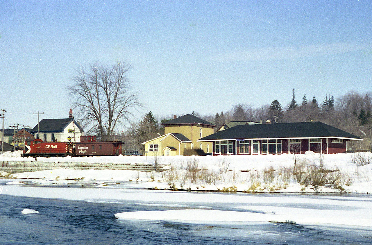 That is a rather dressy looking old CP station visible across the icy winter waters of Trout Creek in downtown St. Marys. No doubt it is because a town electrician is taking up shop there. By the time this image was snapped, the station had outlived its usefulness other than a convenient office for local train crews. As in most localities located at the end of steel back then, a switcher and caboose take up residence when not in use. This view features CP 8147 as well as an old paint style caboose, number unknown. The line to St. Marys is now gone, save for an industrial mile or so back at the Galt sub connection at Zorra, having been removed in 1995. I understand the station is long gone as well. Anyone know when, or why? According to CTG, the 8147 was sold to Progress Rail back in 1999.