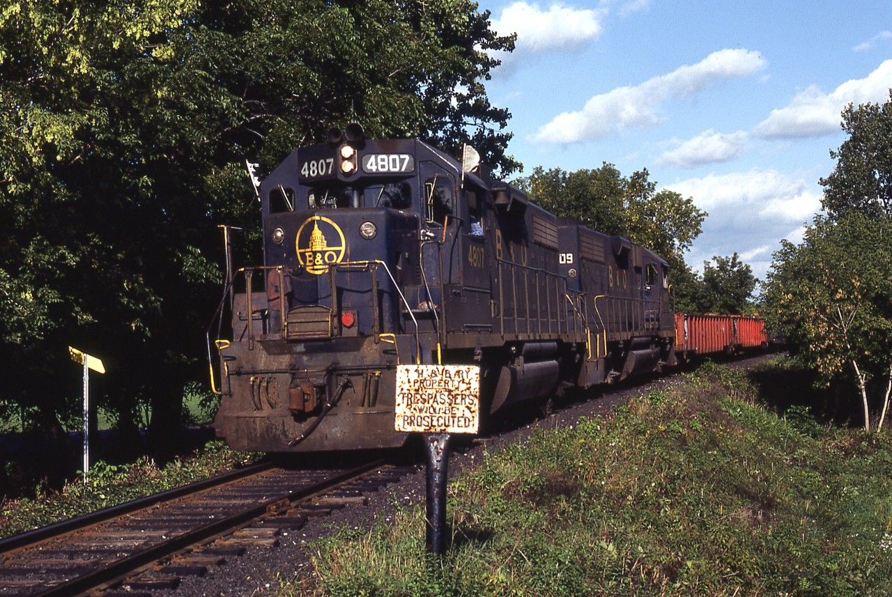 Another scene involving CP's Nanticoke Steel train, this time in West Brantford. Leased GP38's 4807-4809 are sneaking their way out of the tree cover at Gilkison Street, with the remainder of the train still on the Grand River bridge and beyond. These unprotected crossings were not used to daytime moves until this train began to operate on a semi-regular basis. Ironically this group of engines would end up being the 'domesticated' power for use on CSX Canadian District after 1988.
